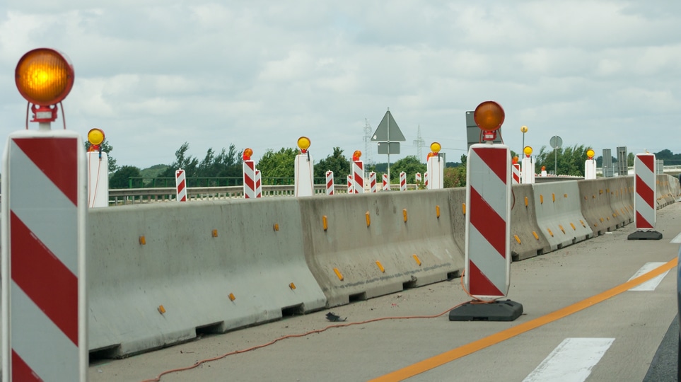 concrete barriers lined up in a road construction area
