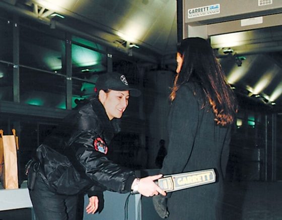 A Woman Checking Another Woman WIth Garrett SuperScanner Metal Detector